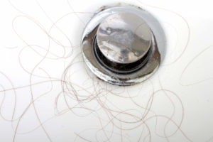 Close-up of hair clogging a sink drain.